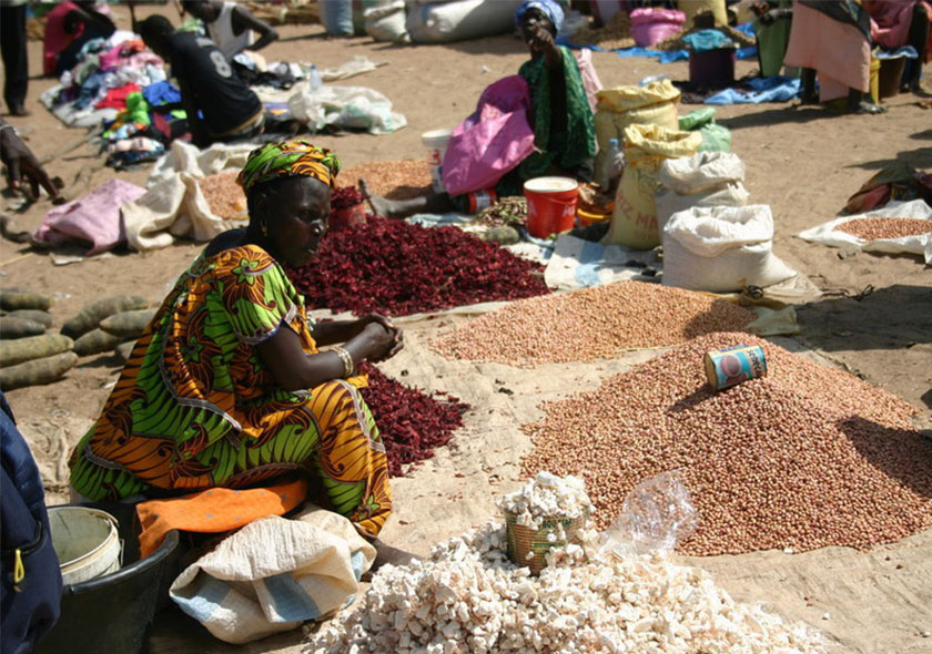 Au cœur du marché hebdomadaire de Nguéniène, une vendeuse de produits locaux s’affaire derrière son étal coloré, soigneusement garni de fruits tropicaux, de légumes frais, de condiments faits maison et d'épices parfumées.